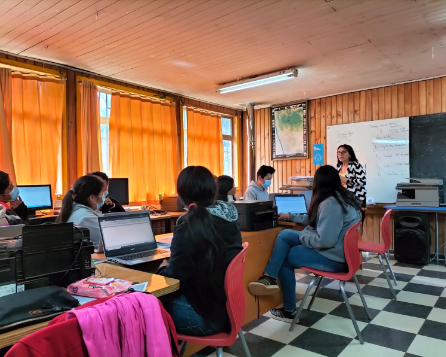 Estudiantes trabajando en exposición del taller mirando los datos.